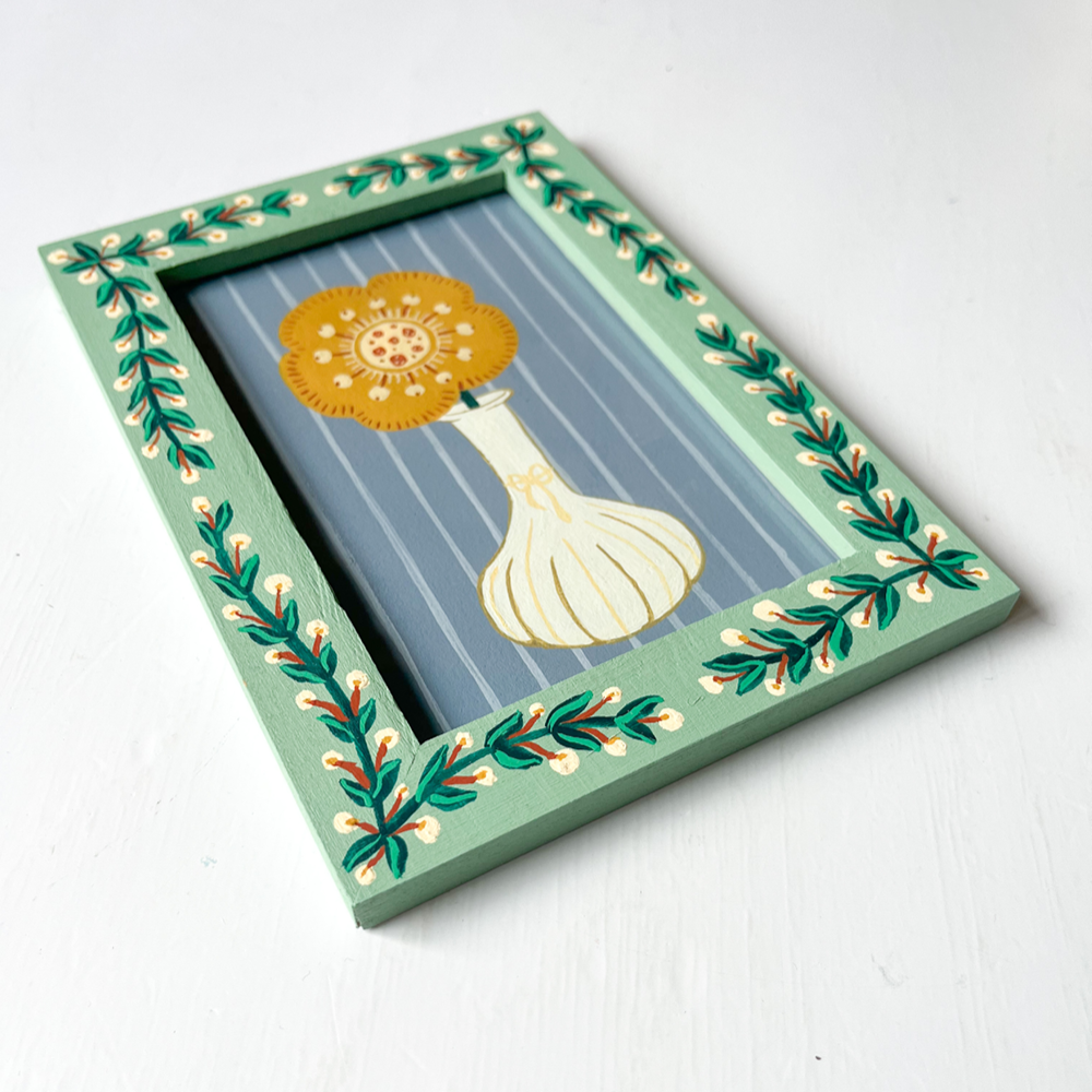 Handbeschilderde groene lijst met schilderij met blaadjes en bloemen