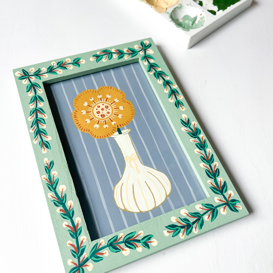 Handbeschilderde groene lijst met schilderij met blaadjes en bloemen